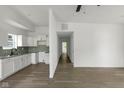 Open-concept living area with hardwood floors seamlessly connects to the kitchen with white cabinets at 1409 N Grant Ave, Indianapolis, IN 46201