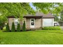 Cozy home with stone exterior, well-kept lawn, and mature landscaping at 1631 S Post Rd, Indianapolis, IN 46239