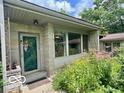 Stone exterior with a decorative front door and lush flower garden leading to the entrance at 1802 Laurel Dr, Columbus, IN 47203