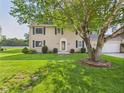 Traditional home with green shutters and a well-manicured front lawn and mature shade tree at 2126 Tartan Rd, Anderson, IN 46012