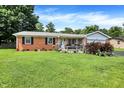 Charming brick home with a well-manicured lawn, flowerbeds, and a welcoming front porch at 2608 E 500 N, Whiteland, IN 46184