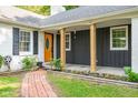Inviting front porch with a brick pathway, beautiful landscaping, and a bright orange front door at 3312 W 42Nd St, Indianapolis, IN 46228