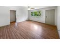 Spacious living room featuring hardwood floors, a ceiling fan, and a view of the yard through a window at 3344 Southwest Dr, Indianapolis, IN 46241