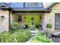Inviting front porch with a vibrant green door, brick accents, and lush landscaping at 3715 Pitkin Rd, Martinsville, IN 46151