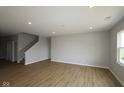 Bright, open floor plan with vinyl flooring, recessed lighting, and staircase adjacent to the living room at 3824 Dutton Dr, Bargersville, IN 46106