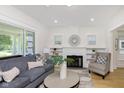 Bright living room featuring a fireplace, hardwood floors, neutral furniture, and a large window at 4226 Cornelius Ave, Indianapolis, IN 46208
