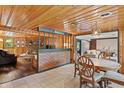 Charming dining room next to a living room, featuring a round table and paneled walls at 4418 North Dr, Quincy, IN 47456