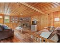 Cozy living room with wood paneled walls, fireplace and wood floors at 4418 North Dr, Quincy, IN 47456