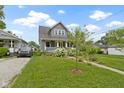 Attractive home with a peaked roof, complemented by lush landscaping and green lawn at 4813 E 11Th St, Indianapolis, IN 46201