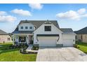 Striking two-story residence with white siding, black trim, a cozy front porch, and an attached three-car garage at 5668 Champion Way, Greenwood, IN 46143
