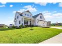 Inviting two-story home with a charming front porch, well-manicured lawn, and a convenient three-car garage at 5668 Champion Way, Greenwood, IN 46143
