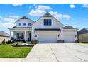 Charming two-story home boasting a welcoming front porch, white exterior, and an expansive three-car driveway at 5668 Champion Way, Greenwood, IN 46143