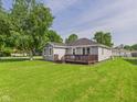 Expansive backyard view showcasing a well-maintained lawn and a cozy wooden deck at 624 10Th St, Chesterfield, IN 46017
