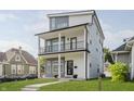 Stunning three-story home featuring modern architectural details, two balconies, and manicured lawn at 704 Parkway Ave, Indianapolis, IN 46203