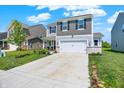 Traditional home with a two-car garage and concrete driveway, set against a backdrop of neighboring houses and green lawns at 741 Scarsdale Ln, Danville, IN 46122