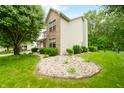 Charming home exterior with lush green lawn and decorative rock garden feature at 7833 Meadow Bend Dr, Indianapolis, IN 46259