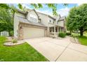 Two story home featuring a two car garage, green lawn, mature landscaping, and inviting porch at 7833 Meadow Bend Dr, Indianapolis, IN 46259