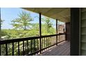 View from covered deck with wooden railing overlooking mature trees and foliage at 8176 Shorewalk Dr # C, Indianapolis, IN 46236
