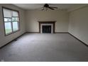 Bright living room featuring a fireplace, neutral carpet, large windows, and ceiling fan at 10150 Beresford Ct, Fishers, IN 46038