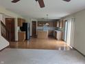 Open concept living room featuring hardwood floors, a ceiling fan, and an adjacent kitchen at 10150 Beresford Ct, Fishers, IN 46038