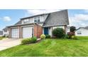 Charming townhome with a lush green lawn, colorful flower beds, and an attached one-car garage at 1124 Paradise Ct # B, Greenwood, IN 46143