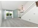 Light-filled living room featuring plush carpeting, fresh paint, and a staircase leading to the upper level at 1124 Paradise Ct # B, Greenwood, IN 46143