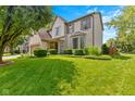 Beautifully landscaped front yard with lush green grass and well-maintained shrubs complementing the inviting home exterior at 12043 Searay Dr, Indianapolis, IN 46236