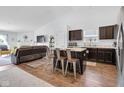 Open-concept kitchen featuring a center island with seating, dark cabinetry, and stainless steel appliances at 12105 Fall Ct, Indianapolis, IN 46229