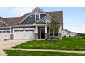 A inviting home with a two car garage, stone accents, and lush green grass at 12500 Morning Ridge Way, Noblesville, IN 46060