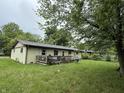 View of the backyard and deck area, perfect for outdoor entertaining and relaxing near mature trees at 1308 Phillips Dr, Indianapolis, IN 46241
