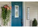 Close-up of the home's vibrant blue front door, accentuated by stylish decor and clear house numbers at 14855 E State Road 46, Columbus, IN 47203