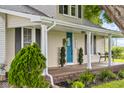 Covered front porch with a striking blue door, seating, and decorative shrubbery, offering a welcoming entrance at 14855 E State Road 46, Columbus, IN 47203