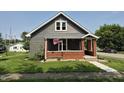 Charming gray home with a cozy front porch, brick accents, and an American flag at 1501 California St, Columbus, IN 47201