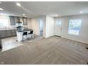 Open-concept living space with neutral carpet flowing into the kitchen with a dark island and seating at 1628 Spann Ave, Indianapolis, IN 46203