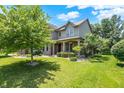 Beautiful two-story home featuring brick and siding exterior, lush lawn, and mature trees at 1808 Woodfield Dr, Greenwood, IN 46143