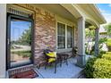 Inviting front porch with a seating area, brick siding, and decorative flower basket at 1808 Woodfield Dr, Greenwood, IN 46143