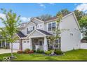 A two-story home with stone accents, a two-car garage, and lovely landscaping create a welcoming curb appeal at 210 Lynnette Way, Cumberland, IN 46229