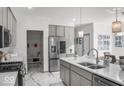 Beautiful kitchen boasts grey cabinets, stainless appliances, white countertops, and modern fixtures at 210 Lynnette Way, Cumberland, IN 46229