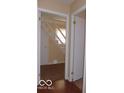 Hallway with stairway access and neutral paint, offering a glimpse of the home's layout at 2250 N Goodlet Ave, Indianapolis, IN 46222