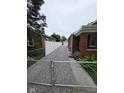 Long driveway leading to the backyard and garage, enclosed with white vinyl and chainlink fencing at 2411 Harlan St, Indianapolis, IN 46203