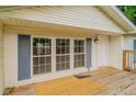 Charming covered front porch with wood decking, white door, and blue shutters on the windows at 3149 Carson Ave, Indianapolis, IN 46227