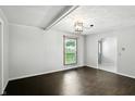 An empty living room with hardwood floors, modern light fixture, and natural light coming in through the window at 3905 E 550 S, Lebanon, IN 46052
