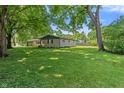 Large, grassy backyard featuring mature trees and the home's exterior at 4350 Sylvan Rd, Indianapolis, IN 46228