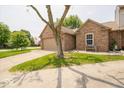 Charming brick home featuring an attached two-car garage and a well-manicured front lawn at 4420 Victory Blvd, Indianapolis, IN 46203