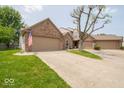 Brick home with attached garage and driveway, with manicured lawn at 4420 Victory Blvd, Indianapolis, IN 46203