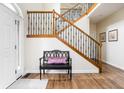 Inviting foyer featuring hardwood floors, staircase with decorative railings, and a stylish entryway bench at 47 Torrey Pine Dr, Brownsburg, IN 46112