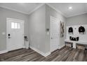 Stylish mudroom featuring coat hooks, a bench, storage, and a decorative front door at 5084 Foxley Park Ln, Avon, IN 46123