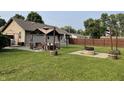 Spacious backyard with green grass, gazebo, firepit, and wooden fence at 52 S 16Th Ave, Beech Grove, IN 46107