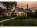Inviting two-story home featuring an attractive lawn, landscaping, and covered entry at 5425 N Delaware St, Indianapolis, IN 46220