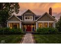 Charming two-story home with a red front door, well-manicured lawn, and inviting walkway at 5425 N Delaware St, Indianapolis, IN 46220